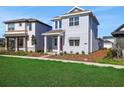 Two-story home with a well-manicured lawn and a red front door at 6553 Rover Way, St Cloud, FL 34771