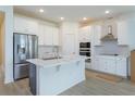 Bright kitchen featuring white cabinets, stainless steel appliances and a kitchen island with quartz countertop at 995 Fiesta Key Cir, Lady Lake, FL 32159