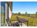 Relaxing back patio overlooking a serene pond, perfect for outdoor dining and enjoying nature at 1188 Oak Valley Dr, Auburndale, FL 33823