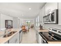 Bright, open-concept kitchen with stainless steel appliances and a view into the living and dining areas at 1188 Oak Valley Dr, Auburndale, FL 33823