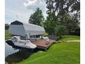 This lakeside property features a private boat dock with a lift and a covered jet ski for waterfront living at 12030 Eagle Point Ct, Leesburg, FL 34788