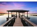 Private dock with sheltered seating providing a serene spot to relax and take in the beautiful lake scenery at 15749 Acorn Cir, Tavares, FL 32778