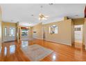 Open-concept living room featuring hardwood floors, a ceiling fan, and lots of natural light at 25642 Oak Aly, Leesburg, FL 34748