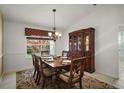 Formal dining room featuring elegant chandelier and backyard views at 25736 Whisper Oaks Rd, Leesburg, FL 34748