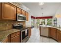 Bright kitchen with granite countertops and stainless steel appliances at 25736 Whisper Oaks Rd, Leesburg, FL 34748