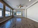 Spacious living room featuring wood-look tile flooring, ample natural light, and a modern ceiling fan at 329 Alcove Dr, Groveland, FL 34736