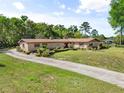 Charming single-story brick home featuring manicured landscaping, a long driveway, and classic architectural details at 3452 N Washington St, Zellwood, FL 32798