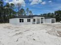 Contemporary home with a black roof, white exterior and an attached garage at 40327 Royal Trails Rd, Eustis, FL 32736