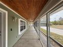 The screened porch has a wood ceiling, a concrete floor, and white trim around the windows and screens at 42836 Royal Trails Rd, Eustis, FL 32736