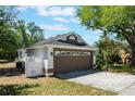 Side angle of the house with a two car garage, white picket fence, and driveway at 815 Thousand Oaks Blvd, Davenport, FL 33896