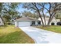 Charming single-Gathering home features mature trees, a two-car garage and beautifully landscaped front yard at 206 Desota Ct, The Villages, FL 32159
