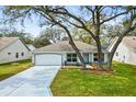 Charming single-Gathering home features mature trees, a two-car garage and beautifully landscaped front yard at 206 Desota Ct, The Villages, FL 32159
