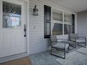 Inviting front porch with stylish seating, decorative rug, and a view of the charming home exterior at 3360 Richmond Dr, The Villages, FL 32162