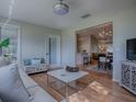 Living room with wood floors, large windows, with an open view to the dining room at 3360 Richmond Dr, The Villages, FL 32162