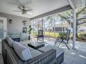 Relaxing screened patio featuring wicker seating and a ceiling fan at 3360 Richmond Dr, The Villages, FL 32162