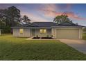 Charming single-story home featuring a well-maintained lawn and a two-car garage at 8 Malauka Run Ct, Ocklawaha, FL 32179