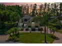 Charming two-story home features a lush green lawn, mature trees, and a brick driveway at 10417 Lake Louisa Rd, Clermont, FL 34711