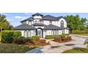 Beautiful two-story home featuring well-maintained landscaping and a concrete circular driveway at 10651 Arrowtree Blvd, Clermont, FL 34715