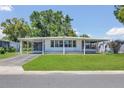 Single-story home featuring a covered carport, well-manicured lawn, and a classic design at 1112 Elkhart Cir, Tavares, FL 32778