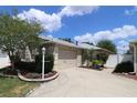 Charming home featuring a beige exterior, lush landscaping, and an attached two-car garage at 1135 Easley Way, The Villages, FL 32162