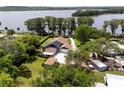 Lakefront home with a solar panel system, outbuildings, mature trees, and a long driveway at 11619 Lane Park Rd, Tavares, FL 32778