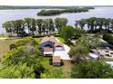 Lakefront home with a solar panel system, pool, mature trees, and a long driveway at 11619 Lane Park Rd, Tavares, FL 32778