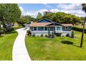 Well-maintained home with lush green lawn, mature landscaping, and a concrete driveway at 11619 Lane Park Rd, Tavares, FL 32778