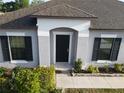 Close-up of the front entrance highlighting the black front door, clean lines, and manicured landscaping at 12807 Sugar Ct, Grand Island, FL 32735