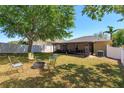 Spacious backyard features a screened lanai, fire pit, and mature trees, perfect for outdoor entertaining at 129 Cabrillo Dr, Groveland, FL 34736