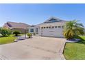 Charming home featuring a well-manicured lawn, beautiful landscaping, and an attached two car garage at 1589 Armstrong Ave, The Villages, FL 32163
