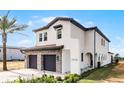 Two-story home boasts a stone-accented garage, black trimmed windows, and neatly landscaped yard at 16028 Trivoli Cir, Montverde, FL 34756