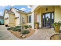 Inviting entrance with brick walkway, manicured landscaping, columns, and detailed front door at 17066 Se 111Th Ter, Summerfield, FL 34491
