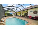 Relaxing screened pool area with ample seating, a waterfall feature, and sunny exposure at 17066 Se 111Th Ter, Summerfield, FL 34491