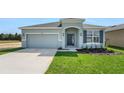 Charming single-Gathering home with a well-manicured lawn, gray exterior, and an attached two-car garage at 179 Bottle Brush Dr, Haines City, FL 33844