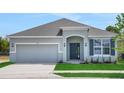 Charming single-Gathering home with a well-manicured lawn, gray exterior, and an attached two-car garage at 179 Bottle Brush Dr, Haines City, FL 33844