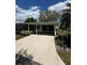 Well-maintained exterior with a driveway, lush lawn, and mature landscaping at 201 Jacaranda Dr, Leesburg, FL 34748