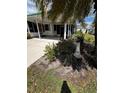 Charming front yard featuring lush landscaping, with mature trees and a manicured lawn at 201 Jacaranda Dr, Leesburg, FL 34748