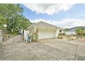 Detached two-car garage with mature trees and landscaping at 202 N Palm Ave, Howey In The Hills, FL 34737