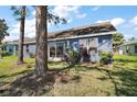 Home featuring a well-maintained backyard with mature trees and lush greenery at 2142 Margarita Dr, The Villages, FL 32159