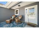 Inviting front porch features comfortable wicker furniture and a stylish welcome mat at 2142 Margarita Dr, The Villages, FL 32159