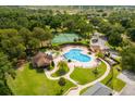 Aerial shot of a community pool and tennis courts surrounded by beautiful landscaping and green spaces at 23814 Sardinia Dr, Sorrento, FL 32776