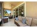 Relaxing screened-in patio featuring a cozy couch, scenic views, and a ceiling fan for added comfort at 23814 Sardinia Dr, Sorrento, FL 32776