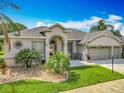 Attractive home with manicured lawn, mature palm trees, and a convenient three-car garage at 25545 Laurel Valley Rd, Leesburg, FL 34748