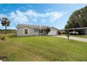 Inviting single story home featuring a lush green lawn with blue skies at 25818 Belle Alliance, Leesburg, FL 34748