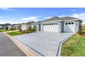 Beautifully designed driveway leading to a two-car garage, complemented by well-maintained landscaping at 2775 Navy Hill Cir, The Villages, FL 32163