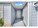 Inviting entrance with a covered walkway leading to a pristine white front door at 2775 Navy Hill Cir, The Villages, FL 32163