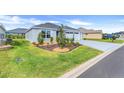 Well-manicured front yard with lush green grass, ornamental shrubs, and a beautifully maintained landscape at 2775 Navy Hill Cir, The Villages, FL 32163