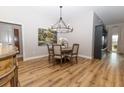 Elegant dining room with chandelier, seating for four, and beautiful wood-look flooring at 3273 Dzuro Dr, Oxford, FL 34484