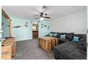 Comfortable living room featuring a plush gray sofa, rustic wood accents, and a ceiling fan at 36337 Terra Ct, Grand Island, FL 32735