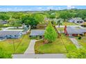 Aerial view of a quaint home with well-maintained landscaping, a long driveway, and bordered by lush trees at 375 N Boyd St, Winter Garden, FL 34787